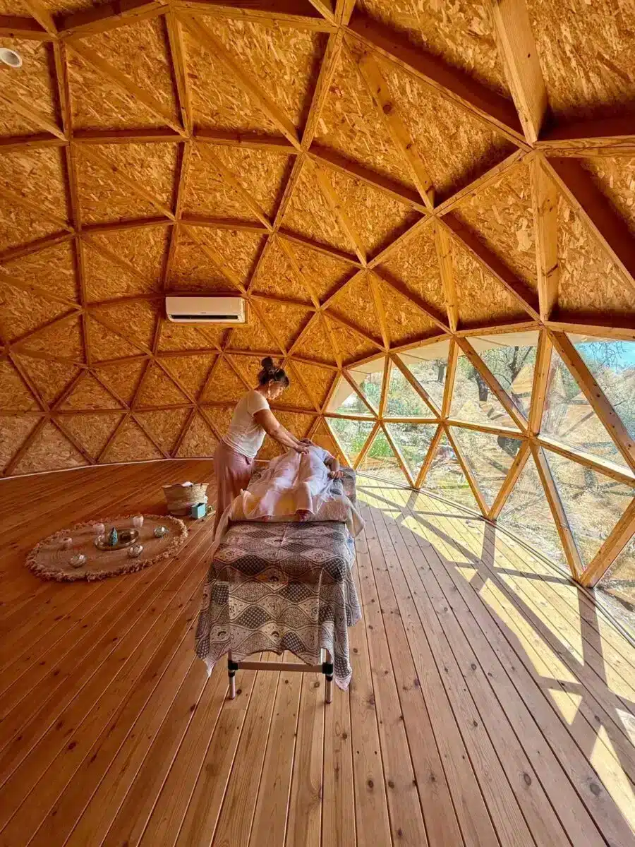 Interior of geodesic dome with warm wooden triangular panels and natural light streaming in at Costa del Soul Málaga