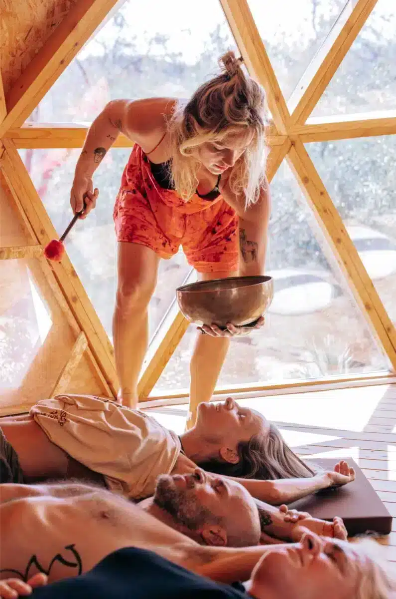 Sound healing ceremony with singing bowl over a guest lying inside a geodesic dome at Costa del Soul retreat in Guaro Málaga