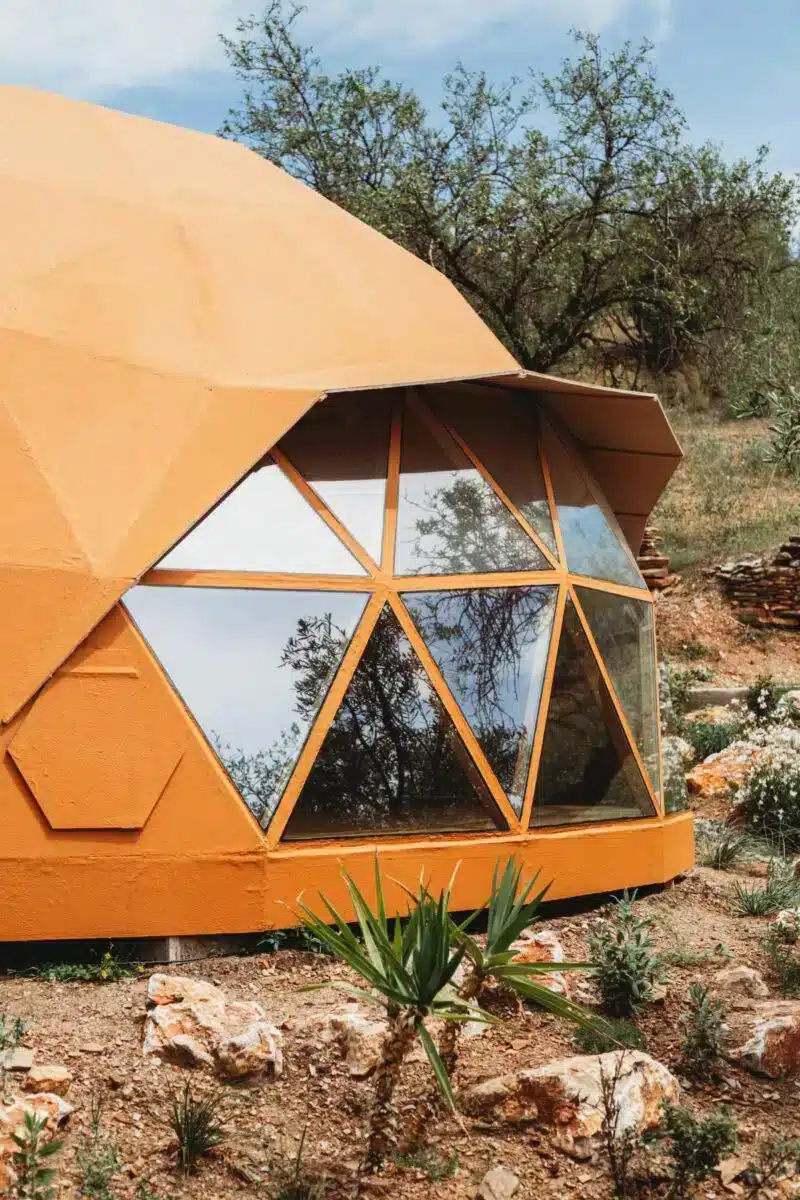 Wooden geodesic dome nestled among olive trees in the natural landscape at Costa del Soul retreat Guaro Málaga