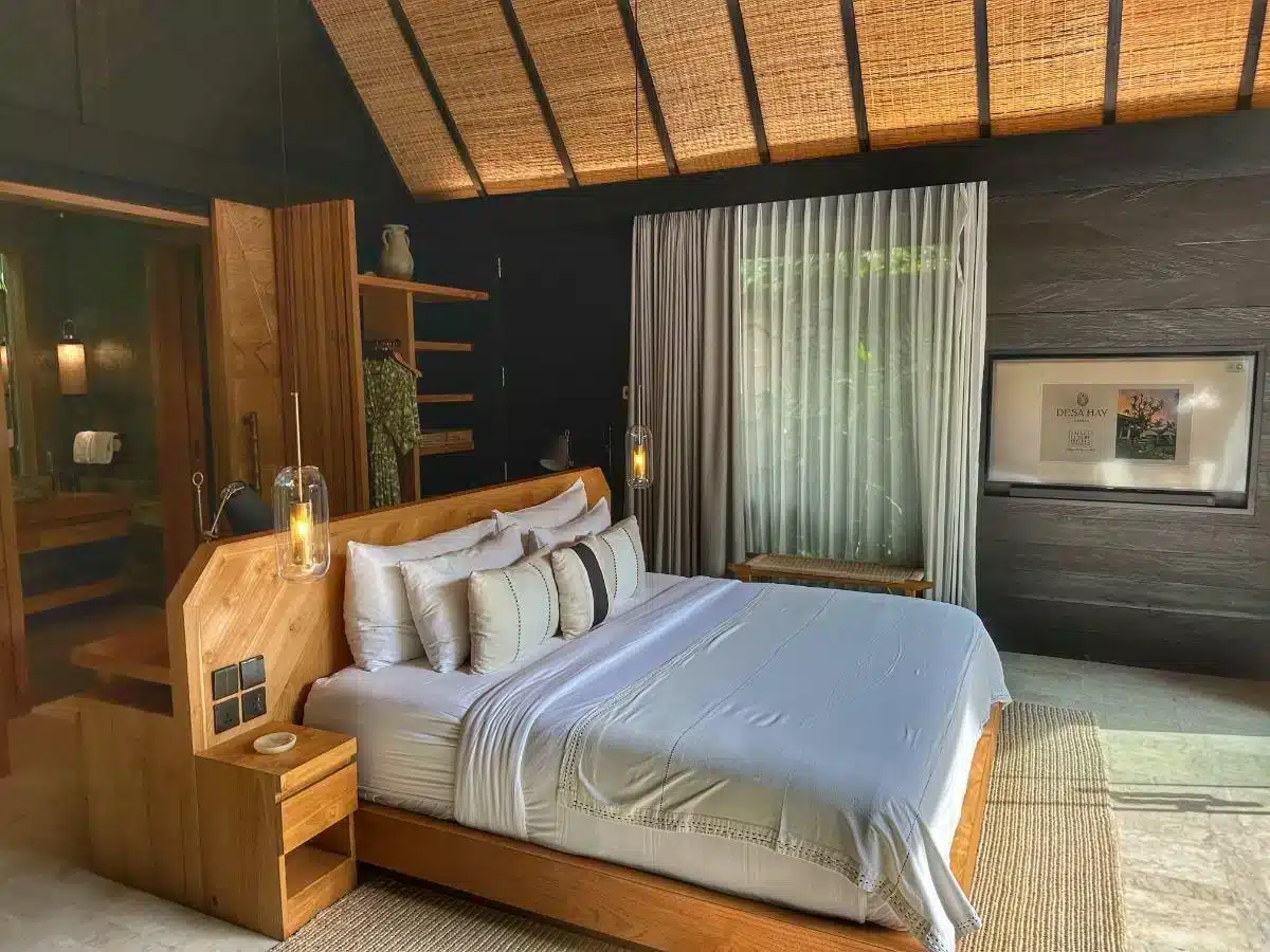 Premium Jabu Villa bedroom interior at Desa Hay Bali with king-size bed wooden headboard and thatched bamboo ceiling