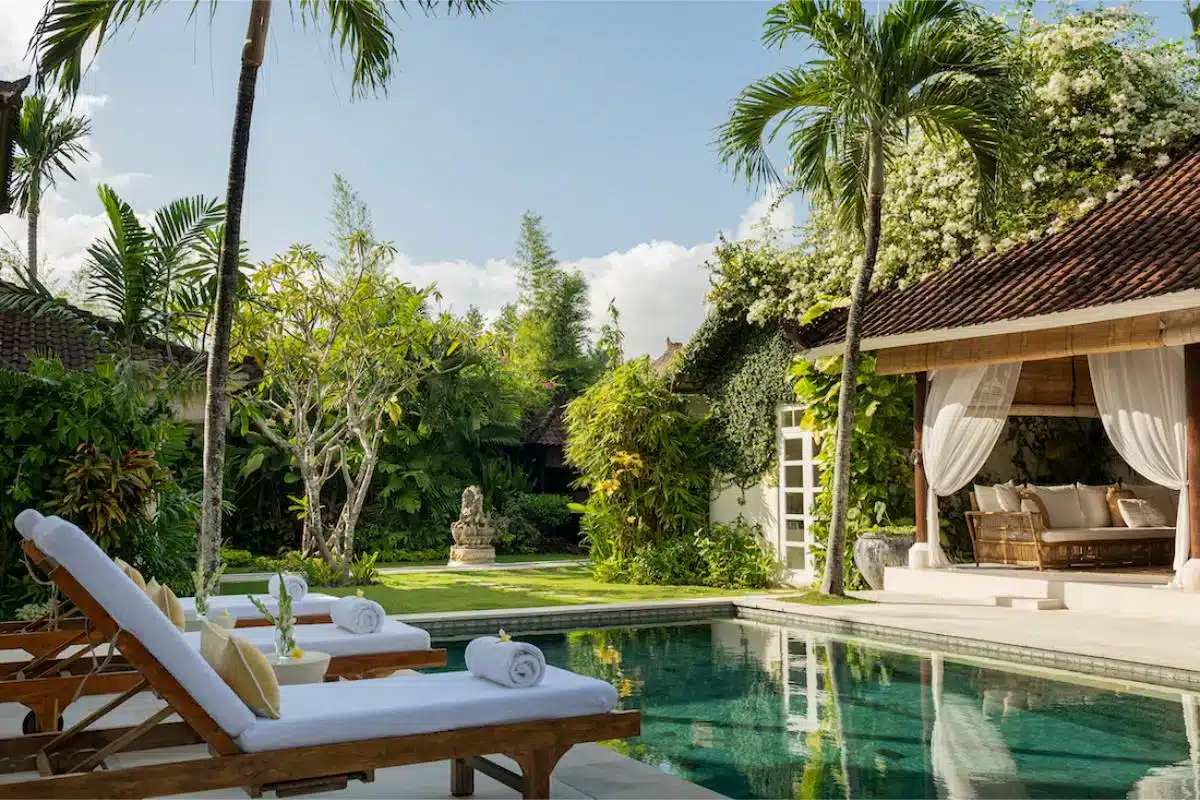 Luxury private villa with pool sunbeds and thatched daybed pavilion surrounded by tropical gardens at Goddess Retreats Bali