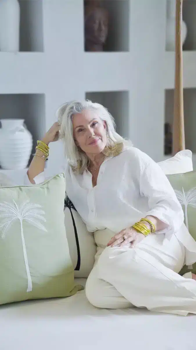 Portrait of Chelsea Ross founder of Goddess Retreats with silver hair and white shirt in a relaxed setting
