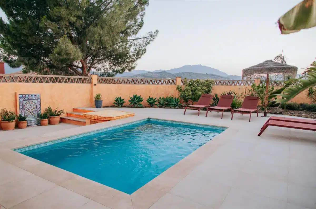 Swimming pool with terrace and sunbeds surrounded by olive trees with panoramic mountain views at Costa del Soul Málaga