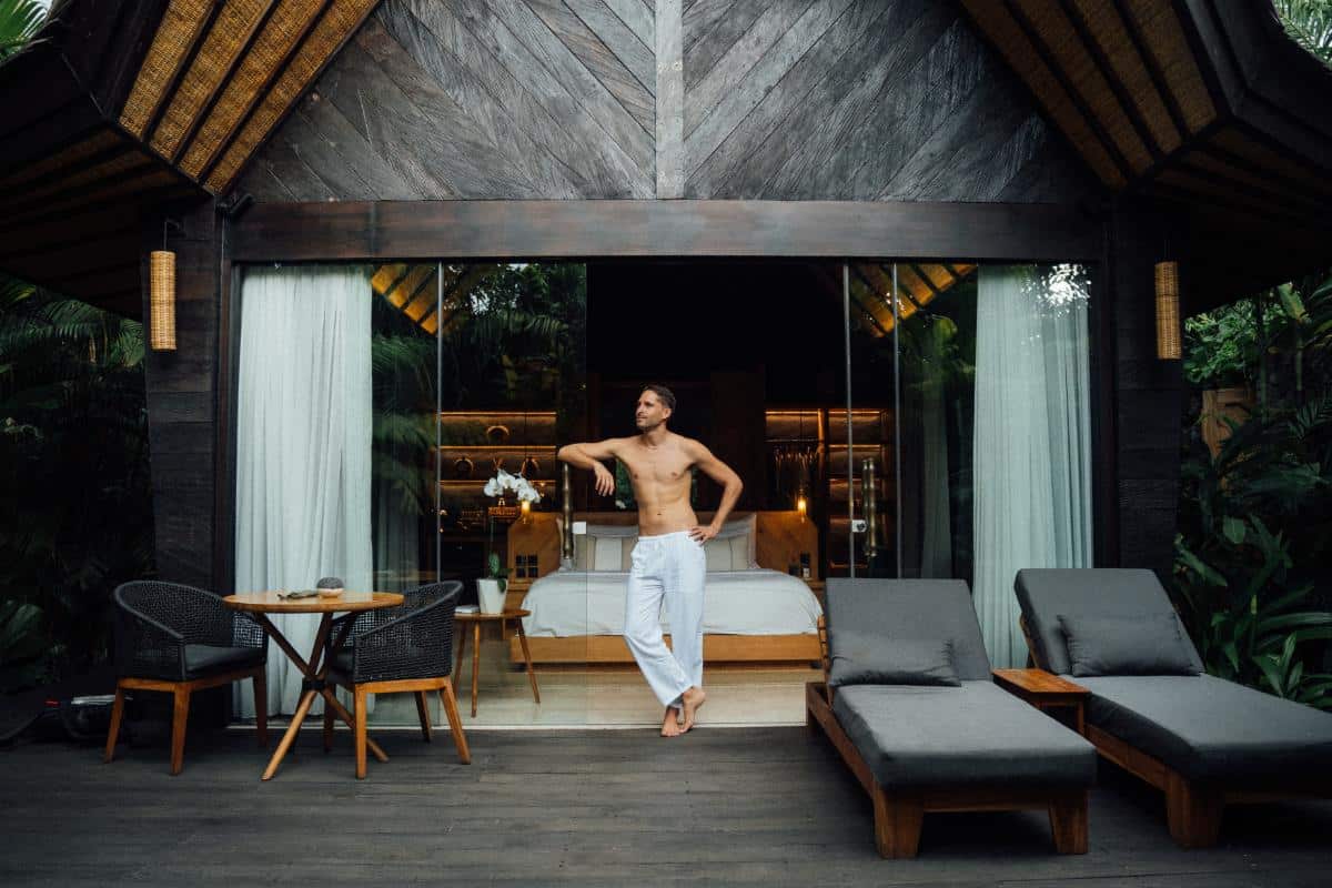 Guest standing on the private villa terrace with daybed and modern design elements at Desa Hay Bali