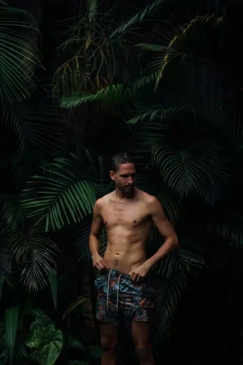Guest walking through tropical garden pathway surrounded by dense vegetation at Desa Hay Bali