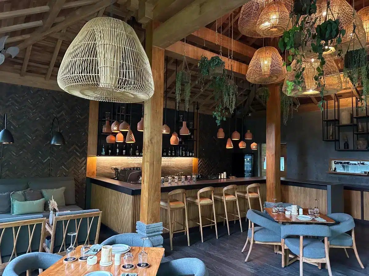 Ijo bar and restaurant at Desa Hay Bali with wooden bar counter woven pendant lights and poolside dining area