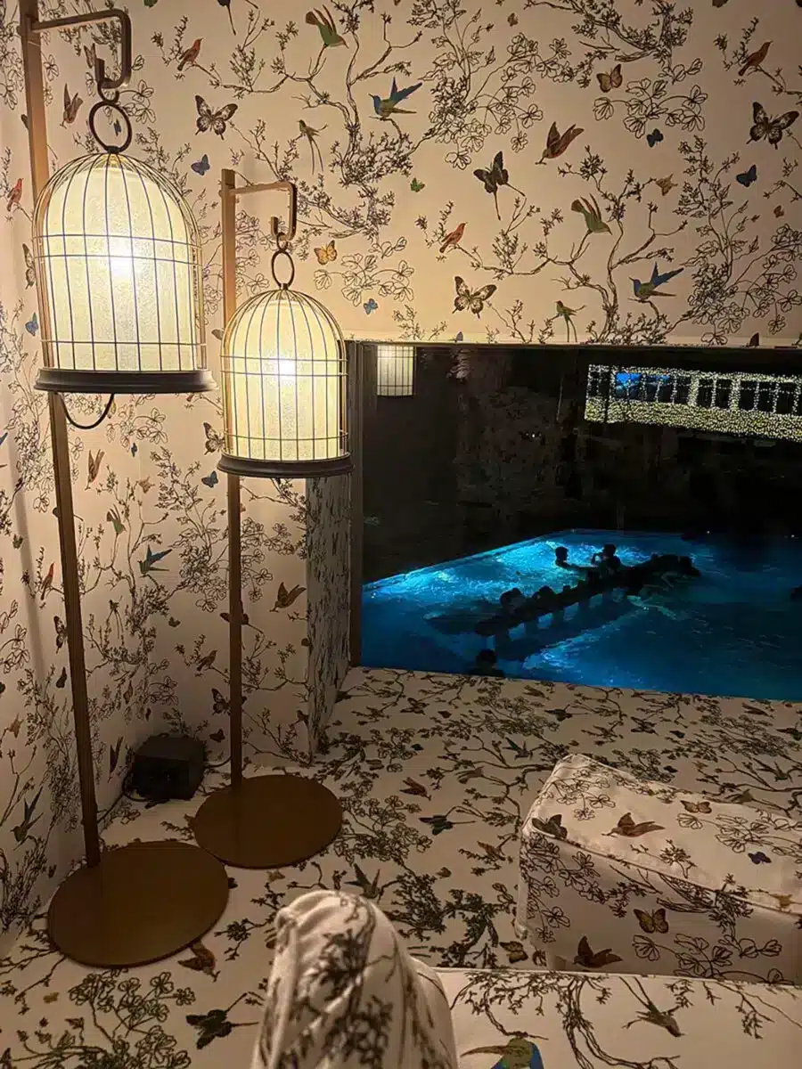 Japanisch inspirierter sensorischer Raum mit Vogelkäfig-Laterne Schmetterlings-Tapete und blau beleuchtetem Pool im QC Terme Milano