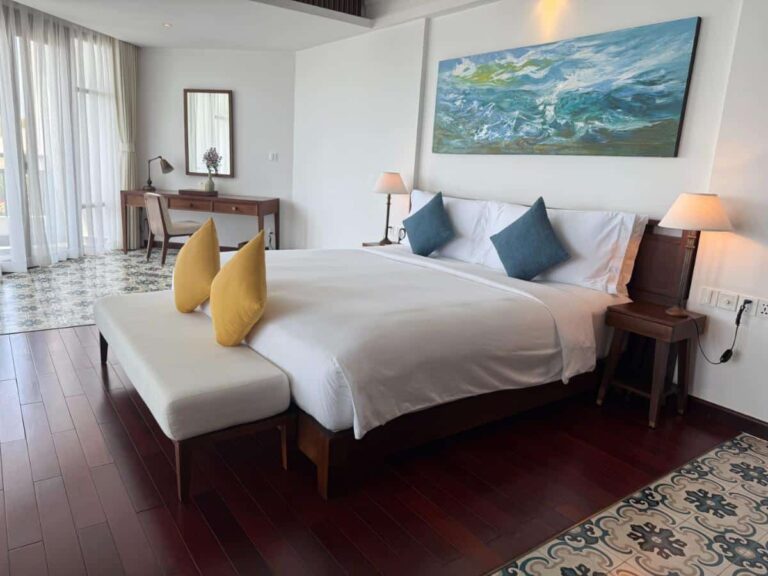 Elegant hotel room with blue accent pillows at The Anam Cam Ranh