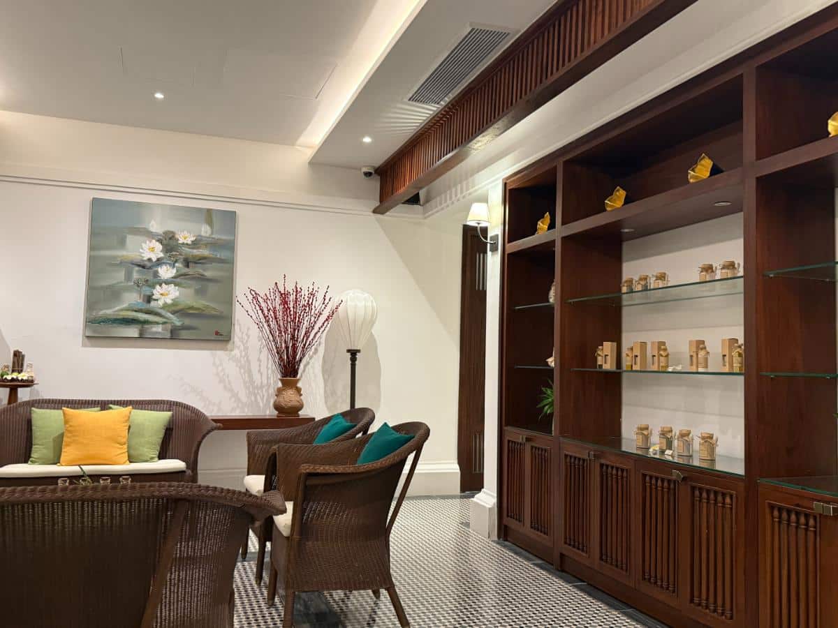 Spa-Rezeption und Lounge-Bereich mit Holzregalen und bequemen Sitzgelegenheiten im The Anam Cam Ranh
