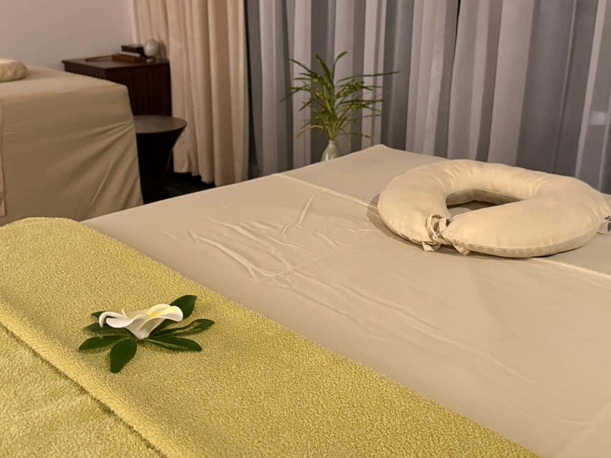 Spa-Behandlungsraum mit Massageliege, Gesichtsauflage und Blumendekoration im The Anam Cam Ranh