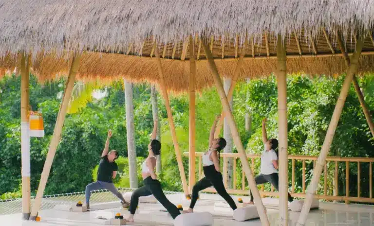 Women surfing ocean waves at luxury Bali surf and yoga retreat