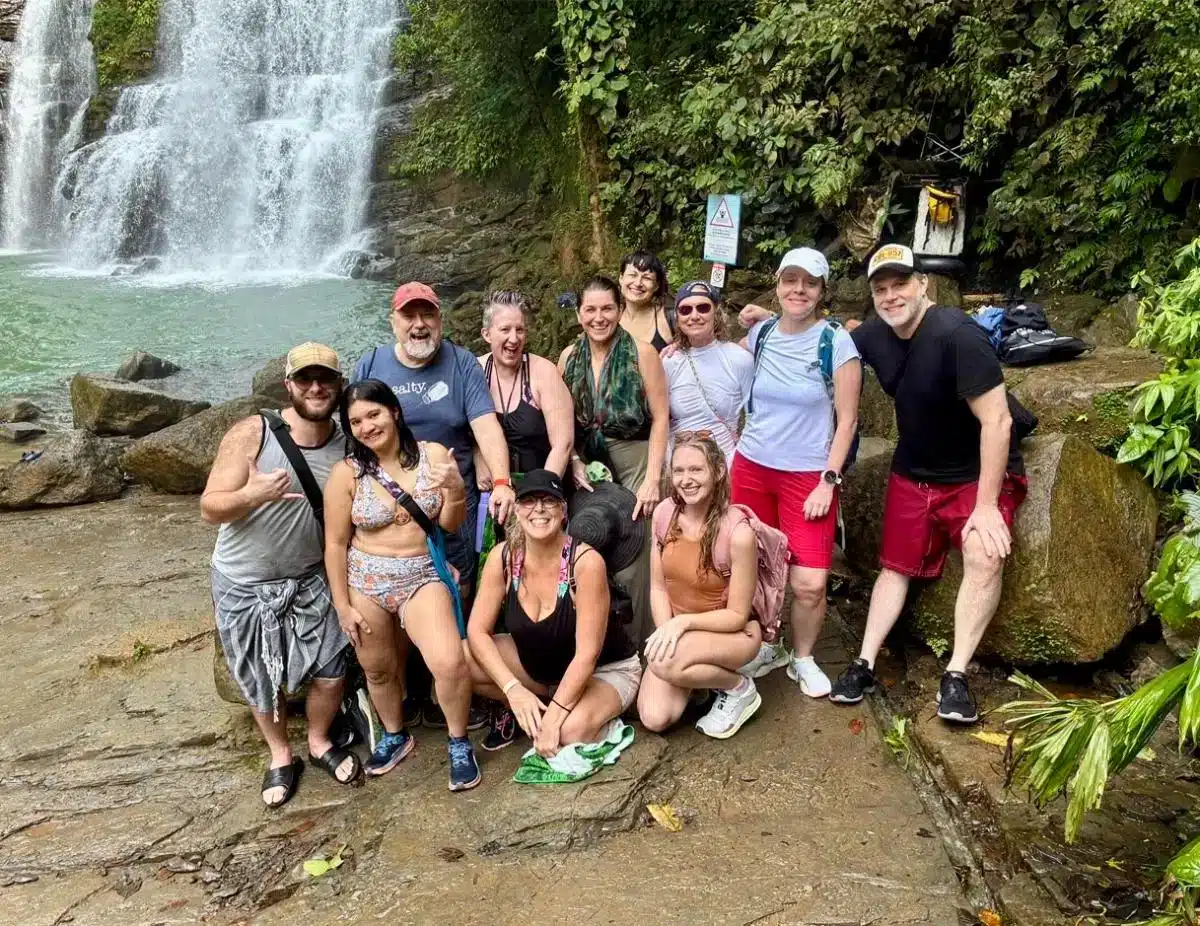 Soul Alive Retreats group photo in front of a waterfall in the Costa Rican rainforest