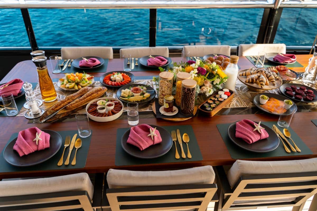 Gourmet dining table set with fresh food fruits and wine aboard the Freedom luxury yacht