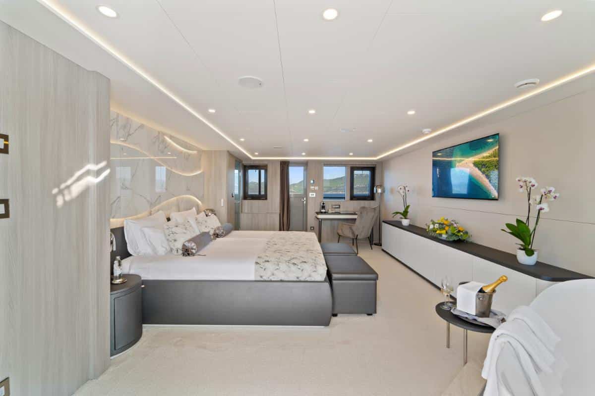 Modern luxury cabin interior with bed and large panoramic windows aboard the Freedom yacht