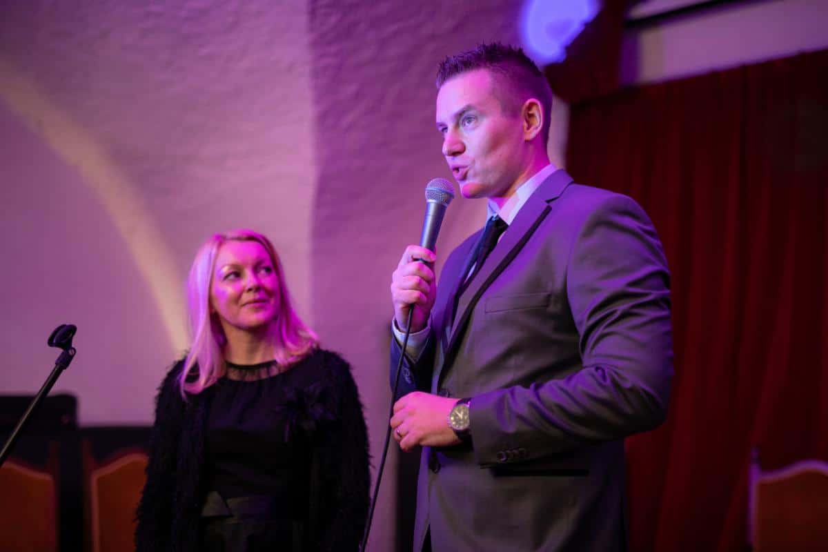 Mitja Mirtic founder of Goolets speaking at a yacht charter event at Lake Bled with purple stage lighting