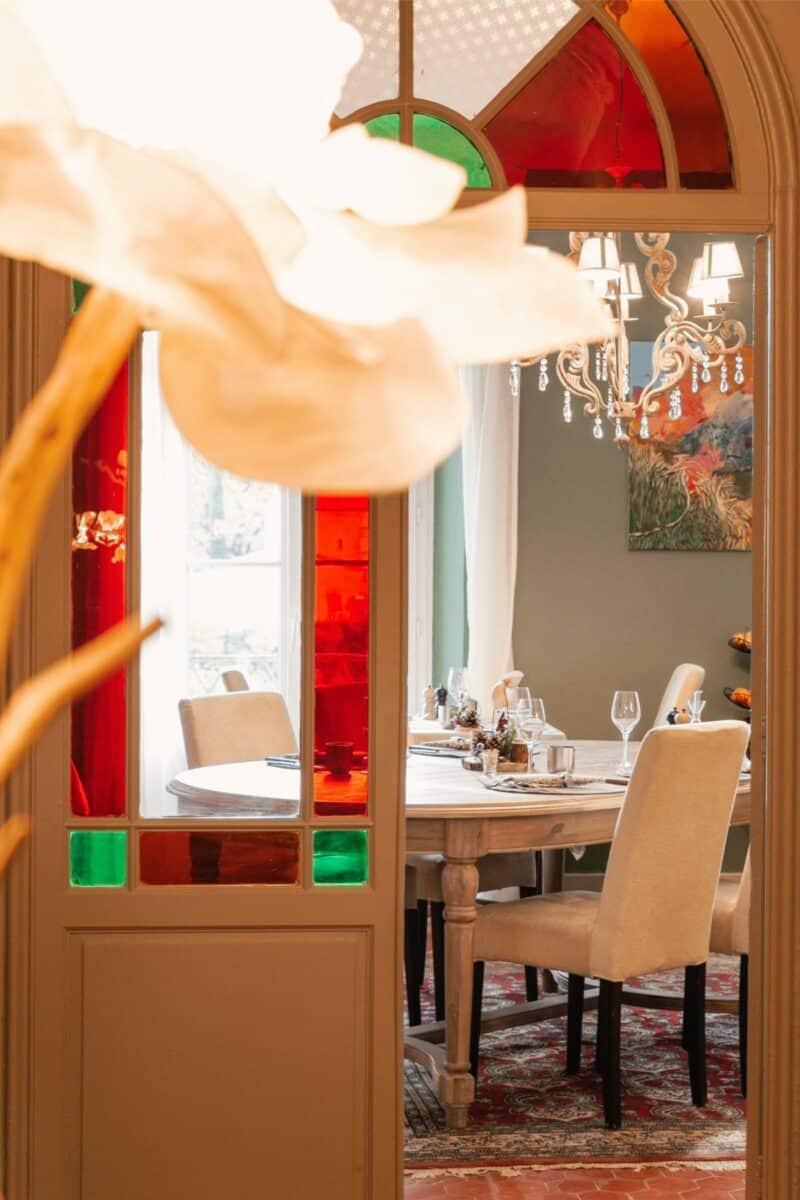 Secret Garden dining room in winter at Lou Calen with crystal chandelier red stained glass windows and white tablecloths