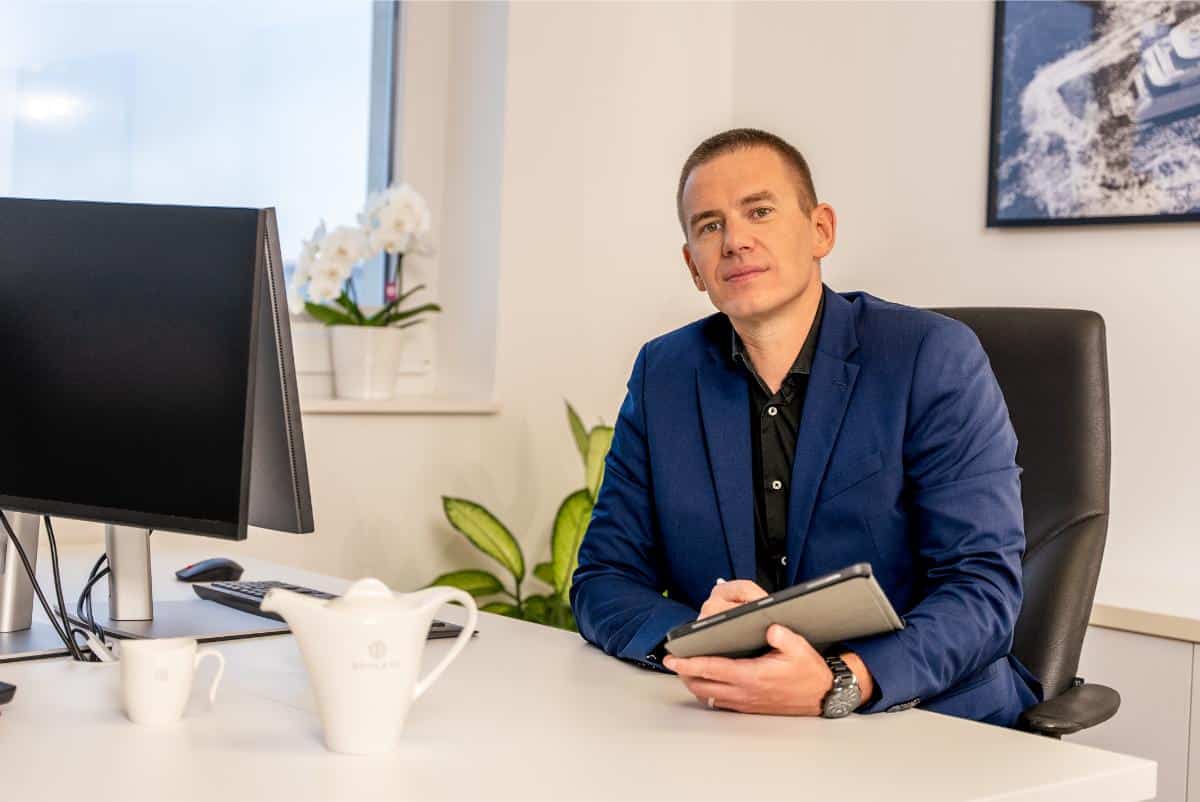 Mitja Mirtic portrait in the Goolets office wearing a navy blazer and taking notes