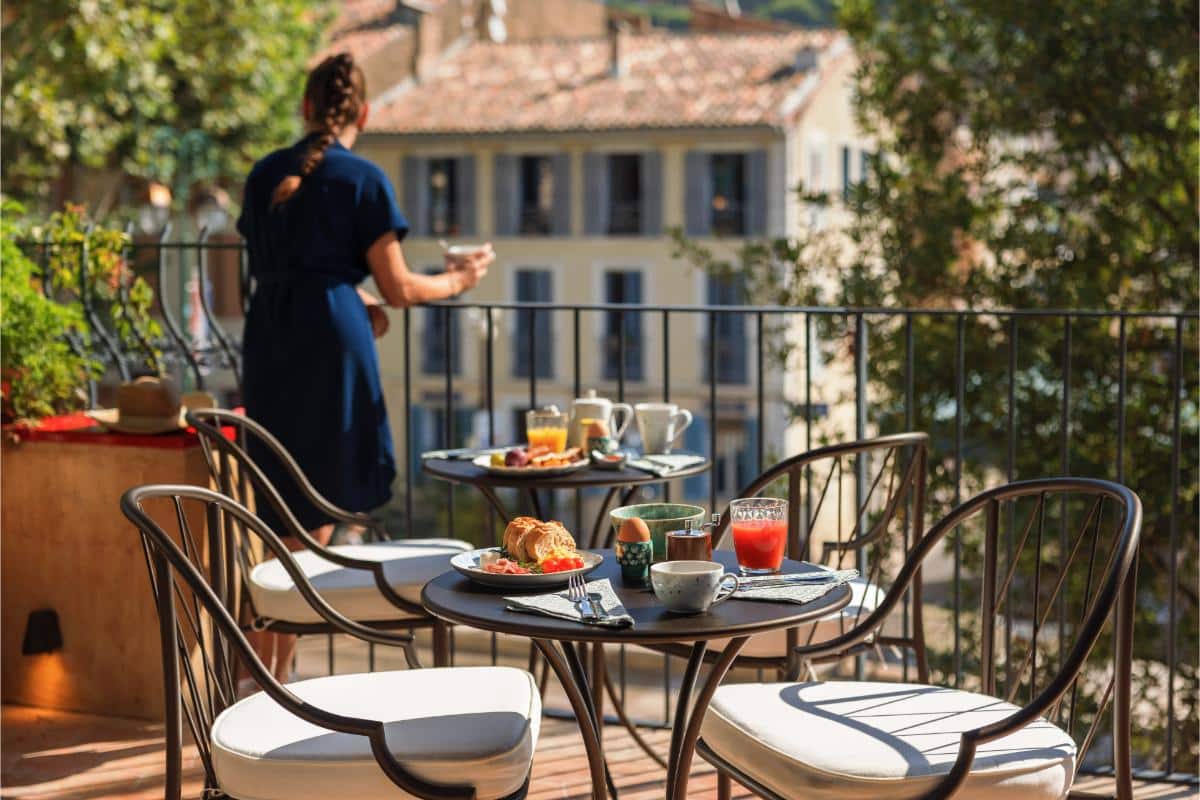 Provençal breakfast spread with pastries croissants and coffee on the outdoor terrace at Lou Calen Cotignac