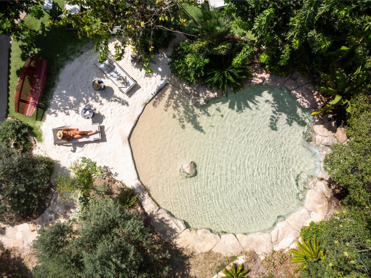 Aerial view of the organic-shaped children's pool surrounded by tropical plants and trees at Lou Calen