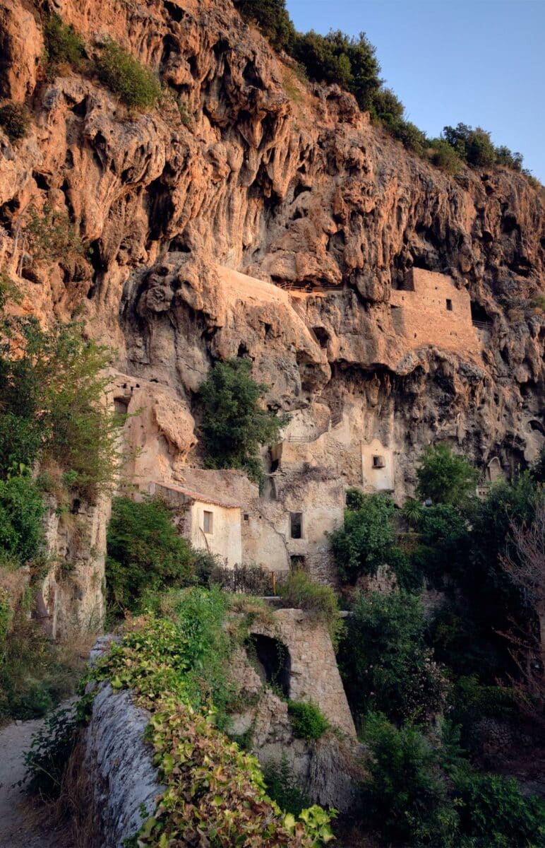 Close-up of the iconic red rock cliff of Cotignac with troglodyte caves carved into the stone face