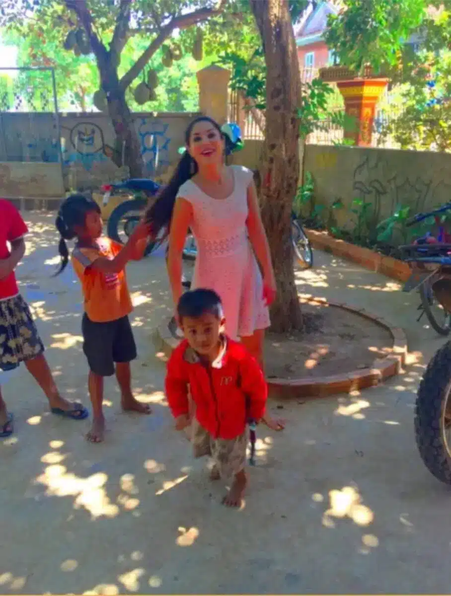 Sayé Yabandeh interacting with young children outdoors during a humanitarian visit in India