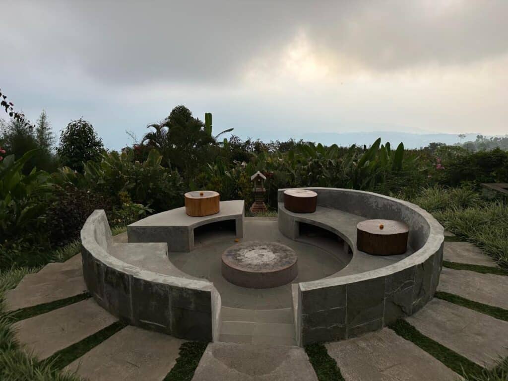 Outdoor circular stone water feature and fire pit at Munduk Moding Plantation Bali surrounded by lush garden planting