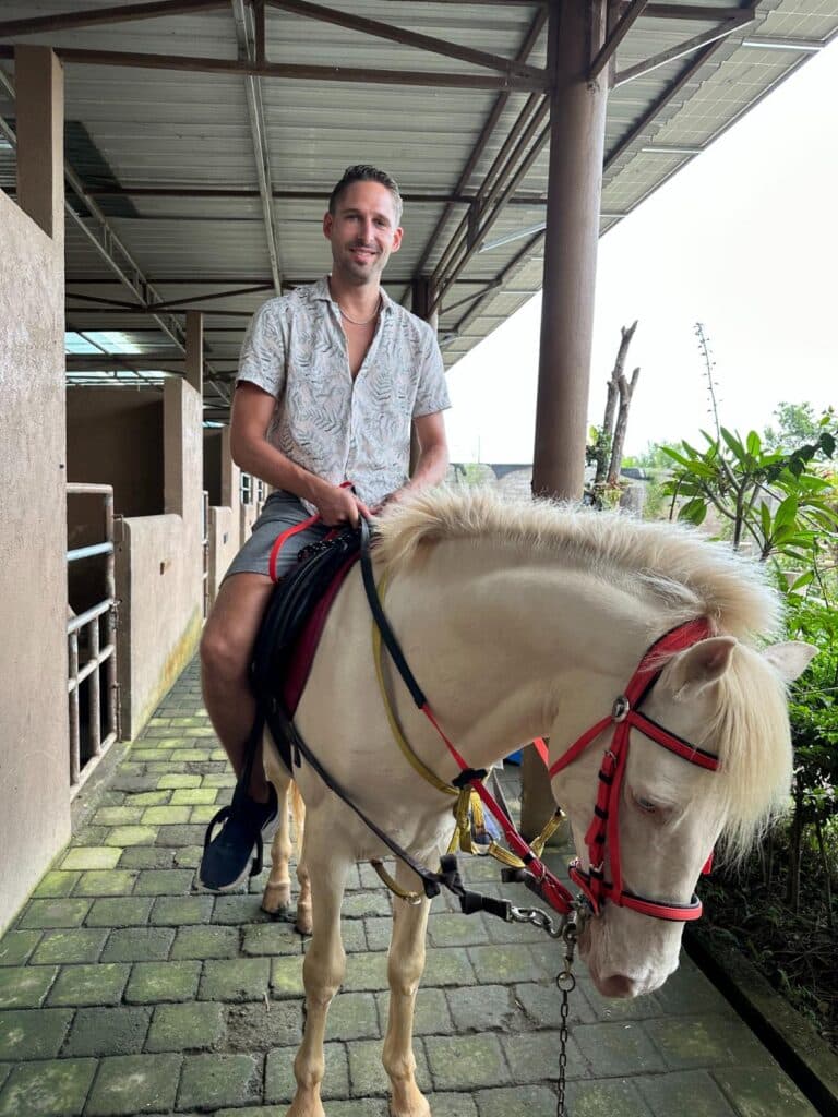 Guest riding on horseback through the coffee plantation grounds at Munduk Moding Plantation Bali during a guided tour