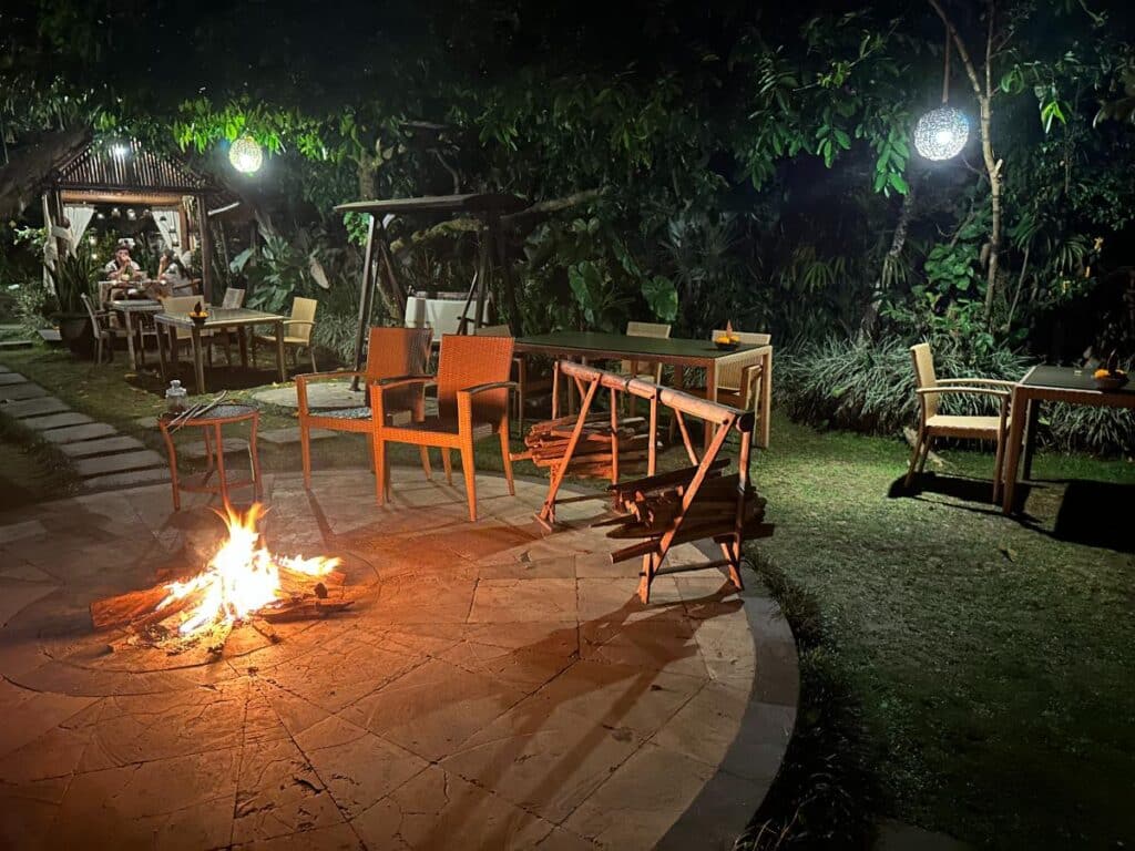 Outdoor evening bonfire seating area at Munduk Moding Plantation Bali with wooden chairs around a fire pit in the garden