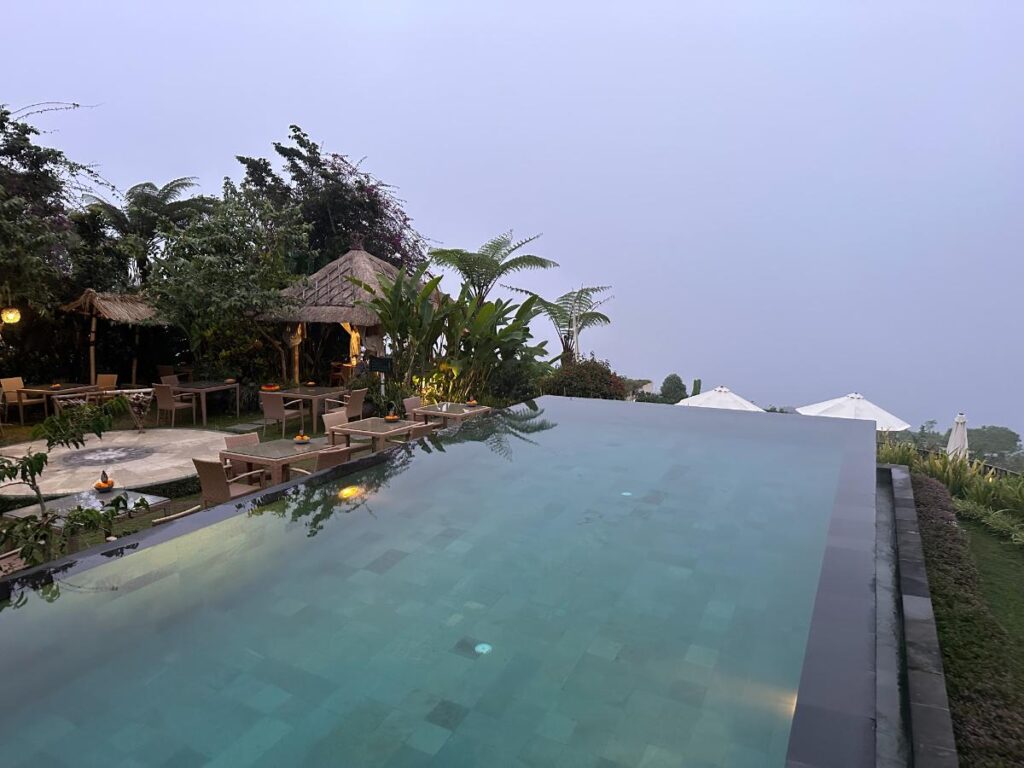 Resort pool area overview at Munduk Moding Plantation Bali with long infinity pool stretching toward the highland horizon