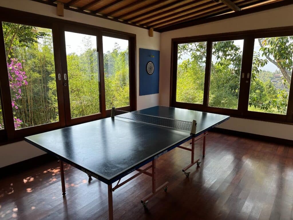 Recreation room at Munduk Moding Plantation Bali with table tennis and panoramic jungle view through full-length windows