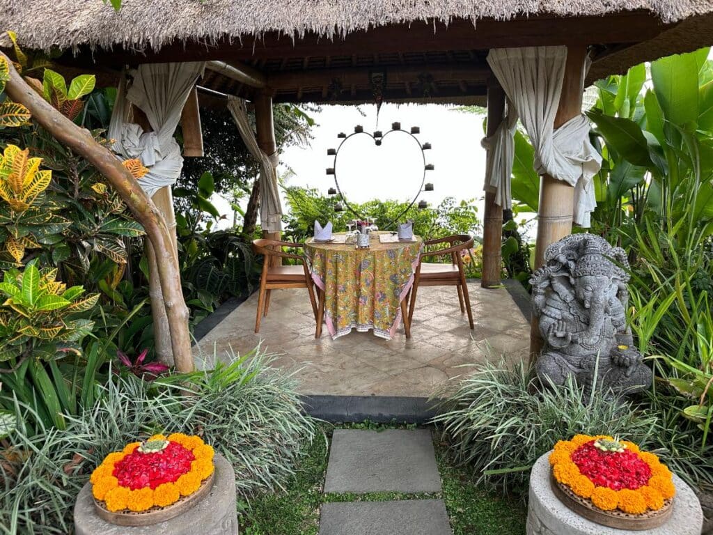 Private romantic dinner pavilion at Munduk Moding Plantation Bali with heart candelabra, Ganesha statue and flower petal offering