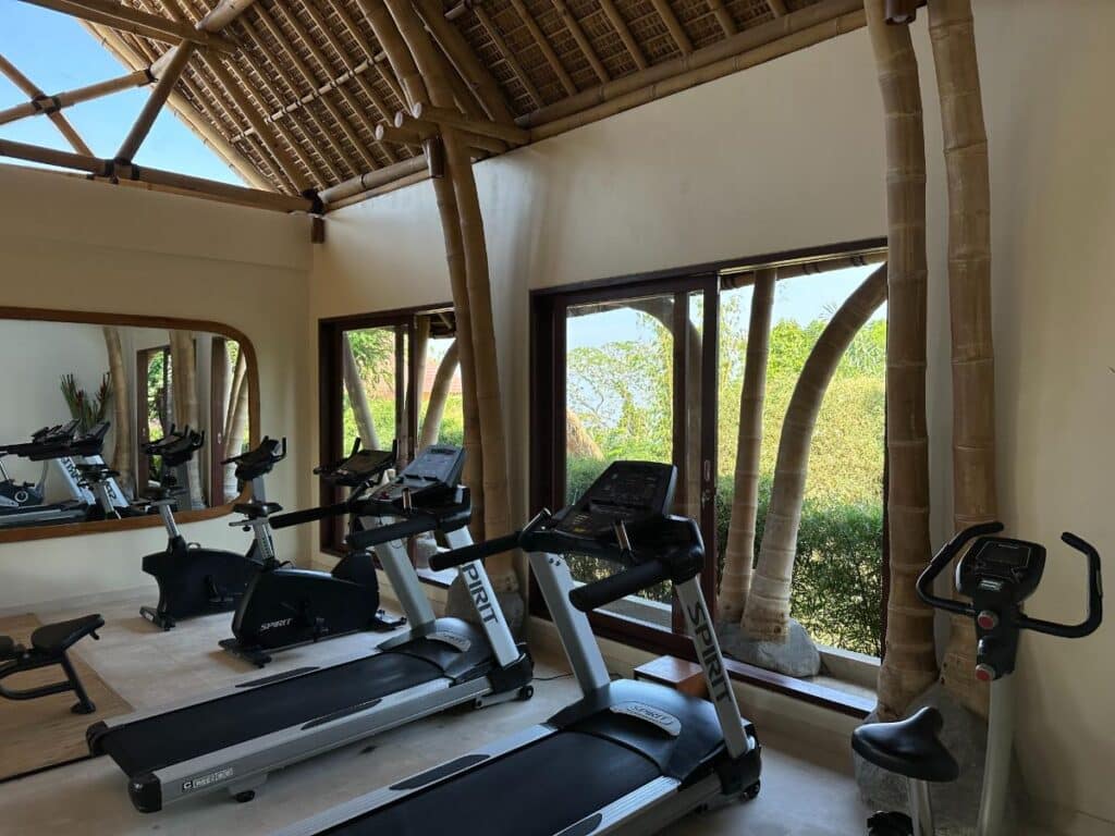 Resort fitness studio at Munduk Moding Plantation Bali featuring modern cardio equipment and natural daylight windows