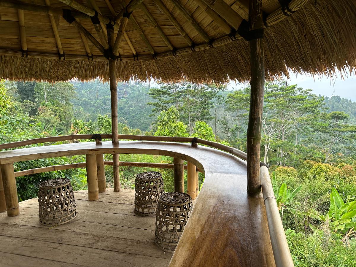 Private terrace dining table for two at Munduk Moding Plantation Bali set with orchids and overlooking misty plantation hillside