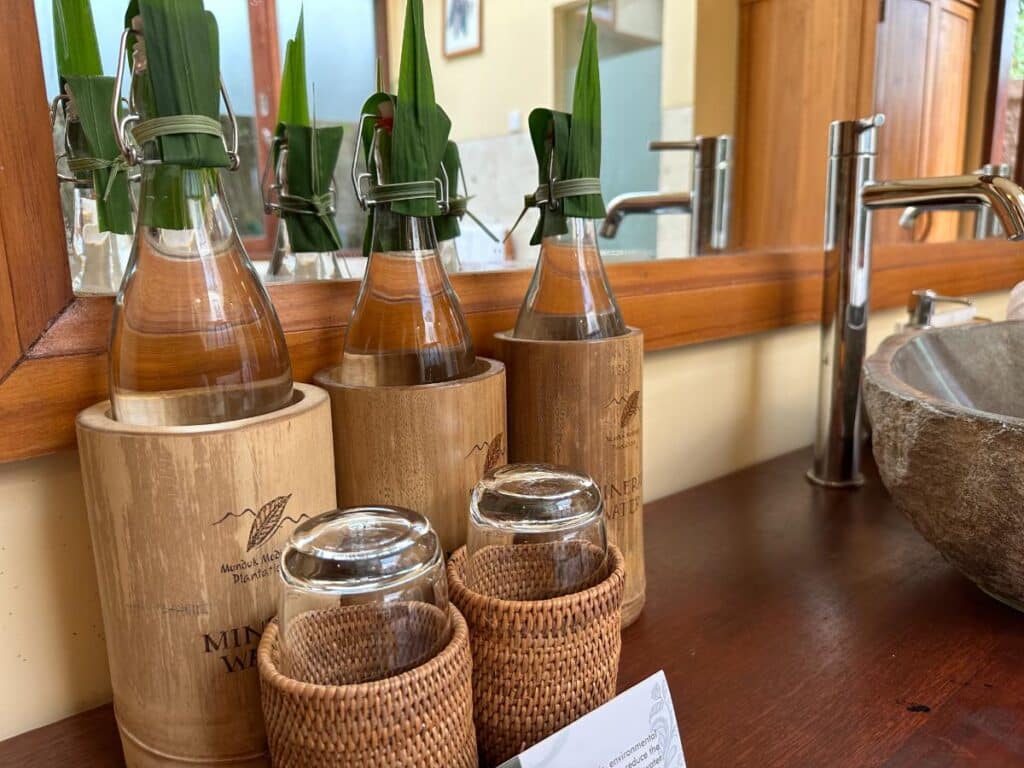 Sustainable bamboo-cased bathroom amenity bottles lined up in Munduk Moding Plantation Bali villa bathroom