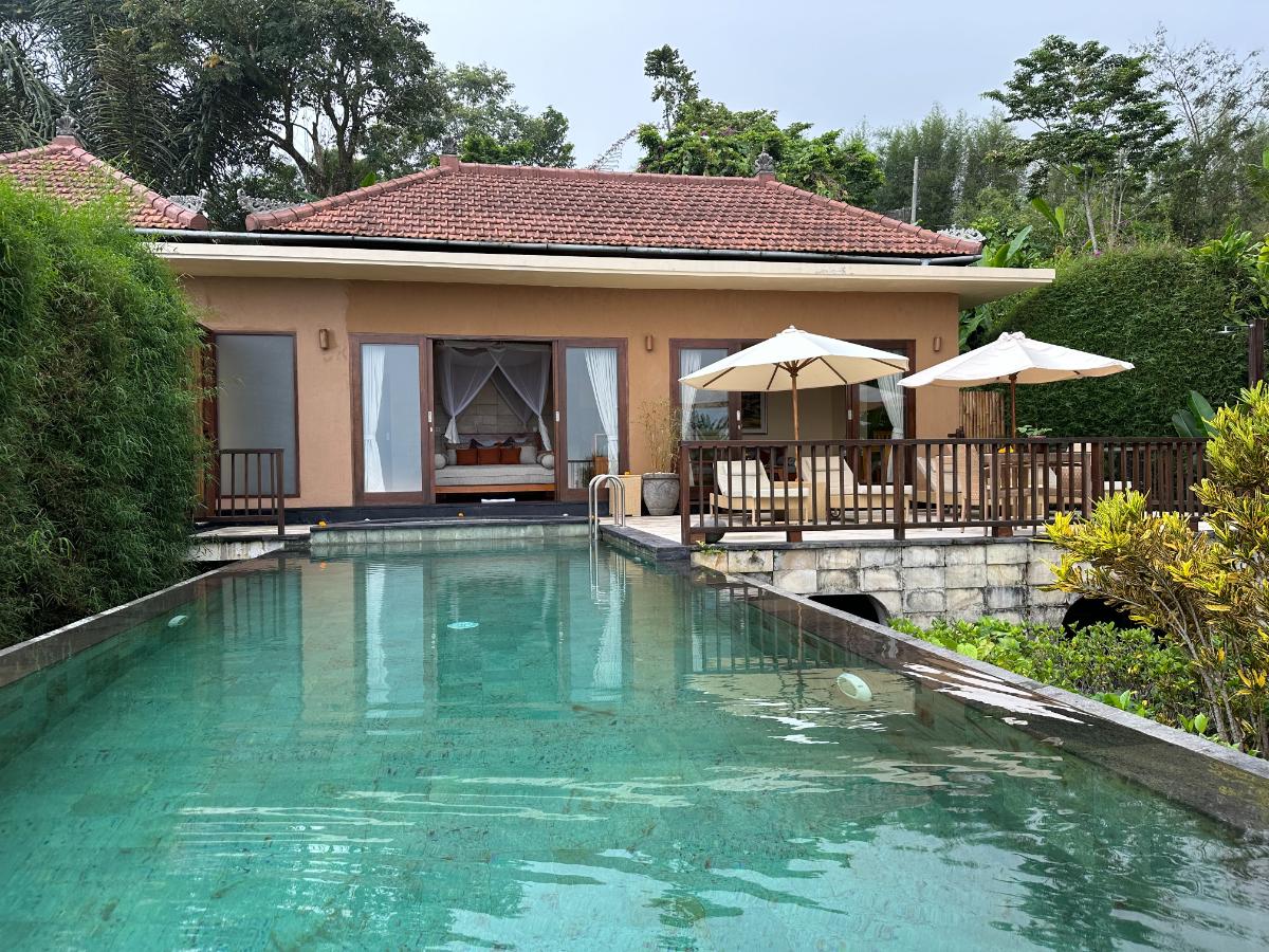 Villa private swimming pool at Munduk Moding Plantation Bali with resort villa building and trellis in background