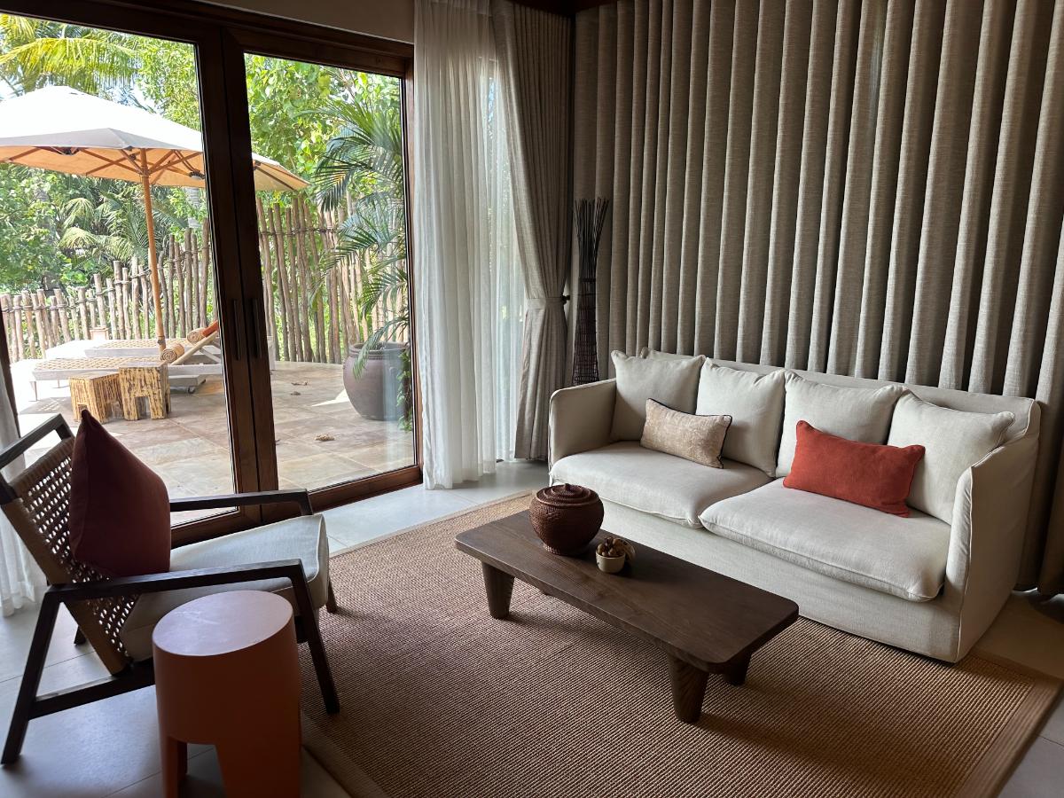 Pool-Villa-Lounge mit Sofa, niedrigem Tisch und Schiebetüren zum Pool, Namia River Retreat, Hoi An, Vietnam