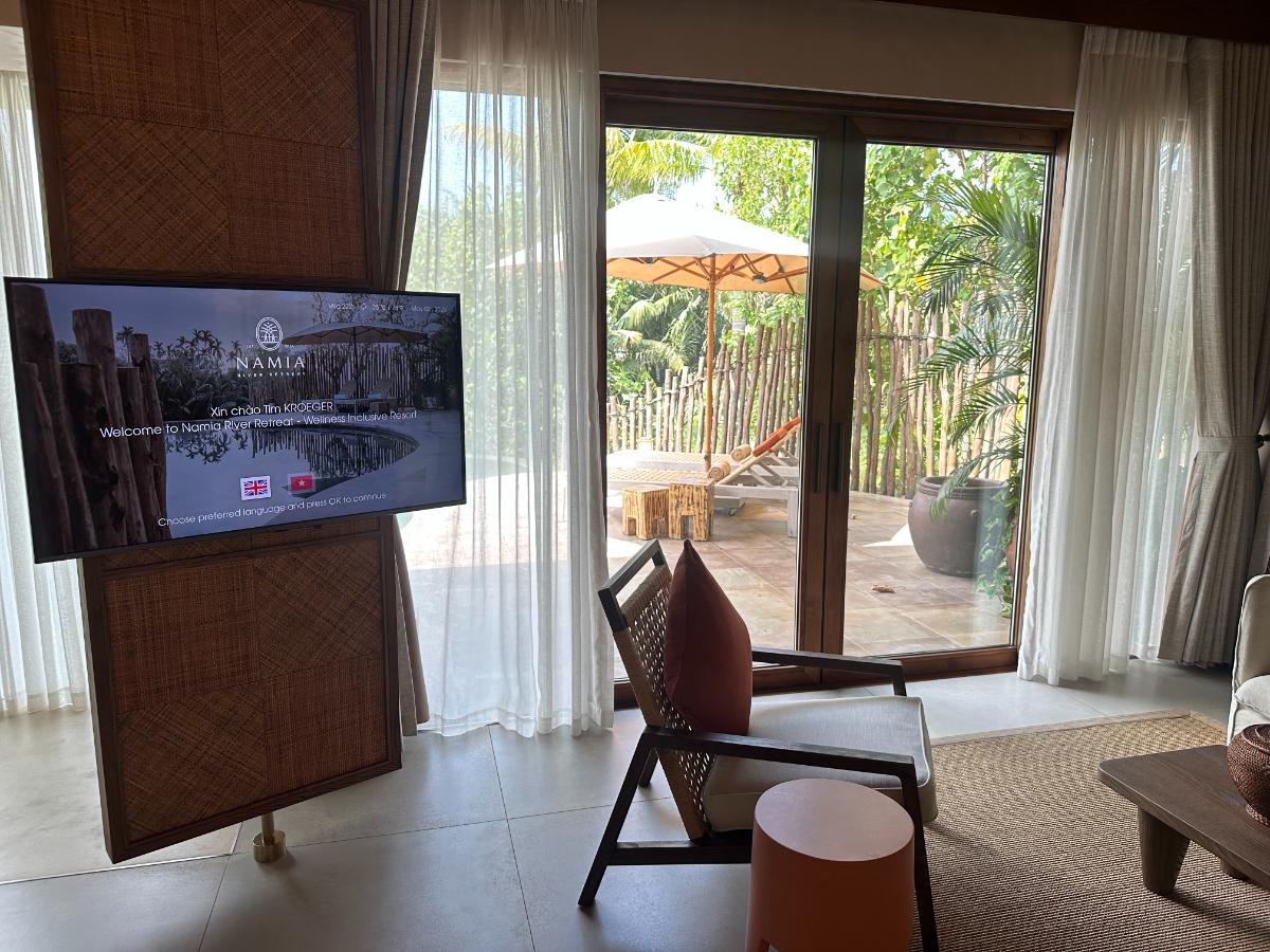 Wohnbereich der Villa mit raumhohen Glastüren, die zum privaten Pool führen, Namia River Retreat, Hoi An, Vietnam