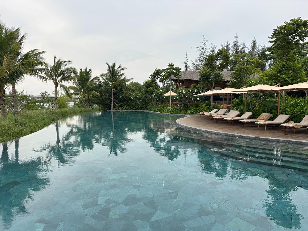 Infinity-Pool und Liegestühle mit Blick auf den Thu Bon Fluss, Namia River Retreat, Hoi An, Vietnam