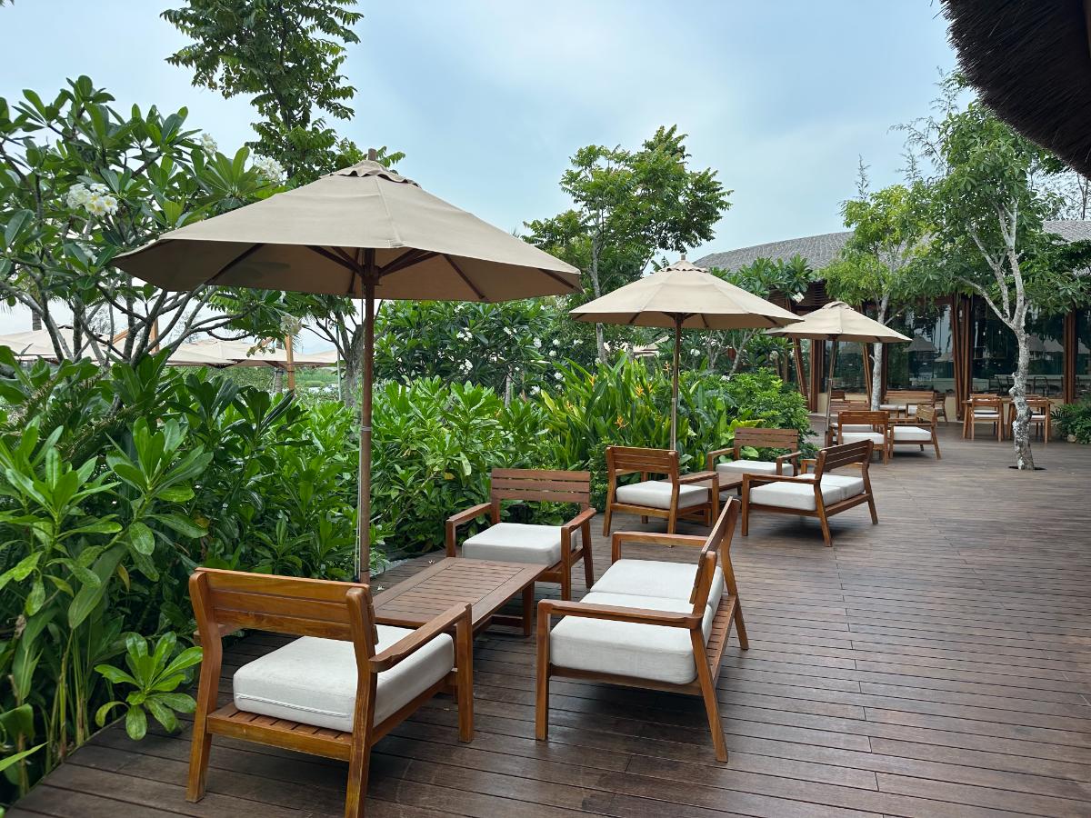 Hauptpooldeck mit Holzliegen und Sonnenschirmen umrahmt von Gärten, Namia River Retreat, Hoi An, Vietnam