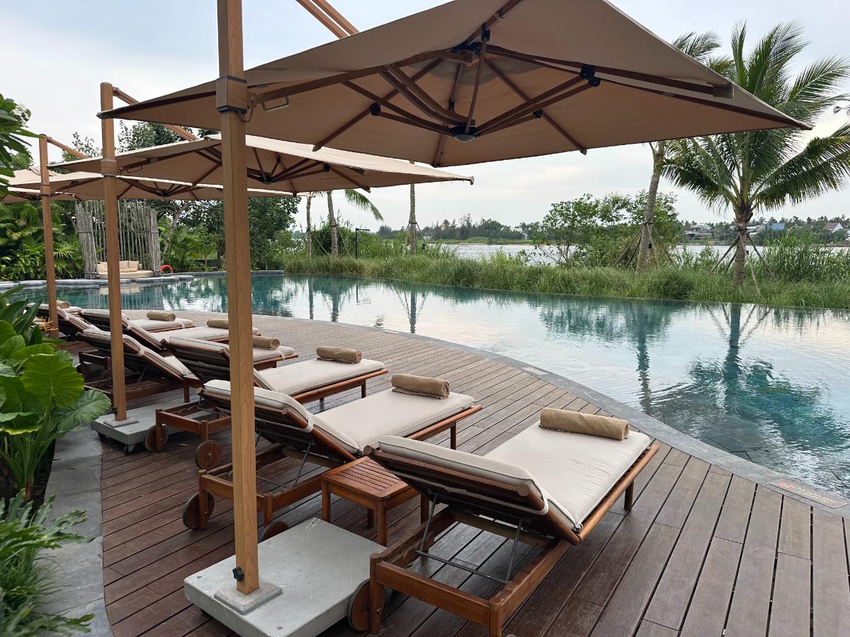 Liegestühle am Infinity-Pool mit Blick auf den Thu Bon Fluss dahinter, Namia River Retreat, Hoi An, Vietnam