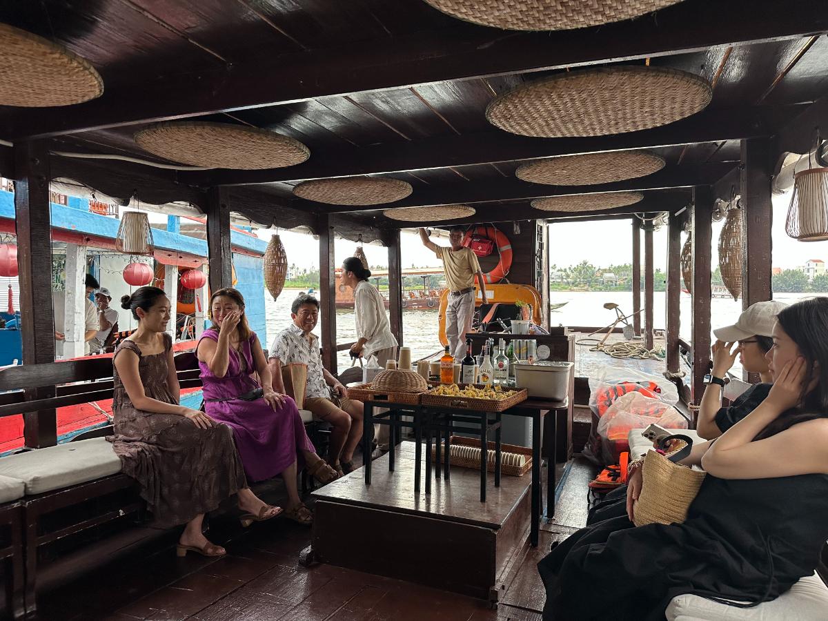 Gäste versammeln sich in der Lounge der Namia Flusskreuzfahrt mit Laternen, Hoi An, Vietnam
