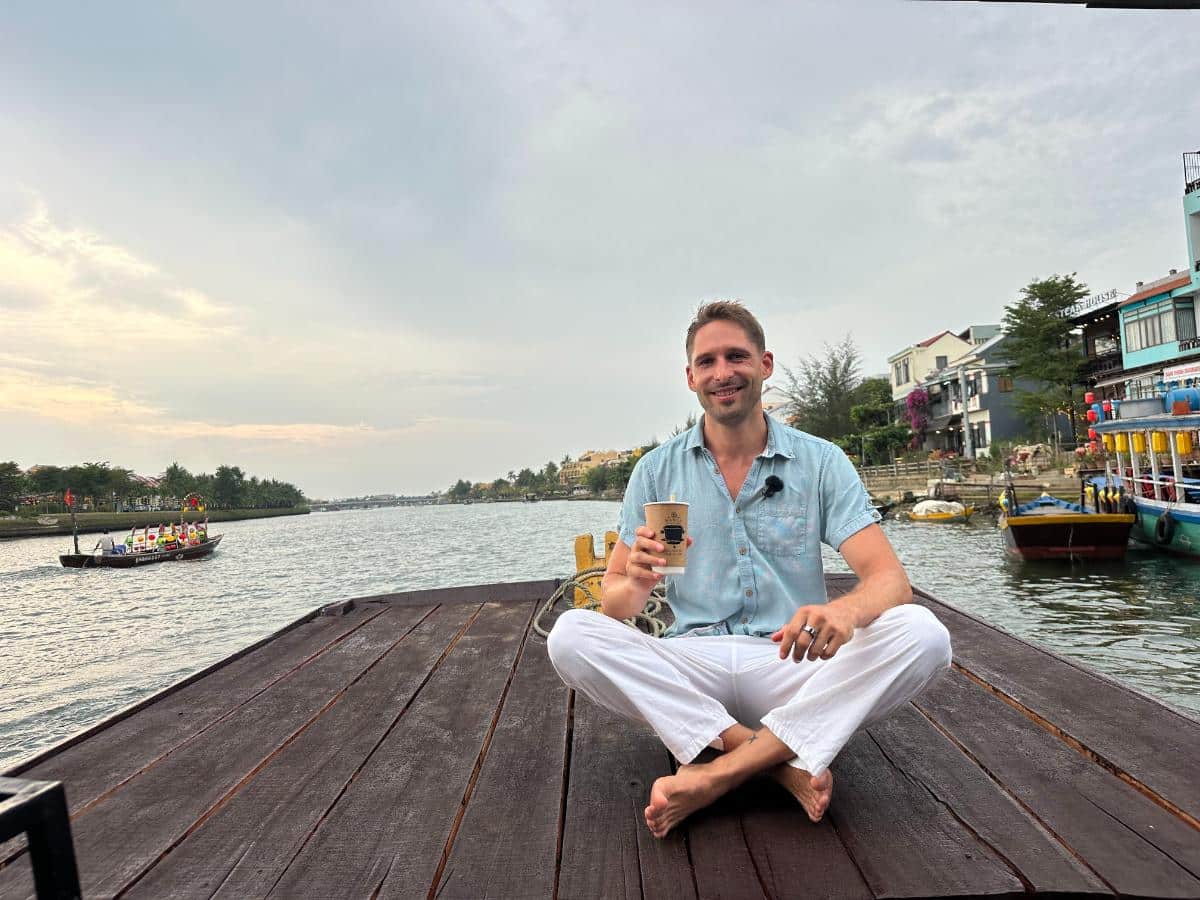 Gast mit einem Drink am Bug der Namia Flusskreuzfahrt, Thu Bon Fluss, Hoi An, Vietnam