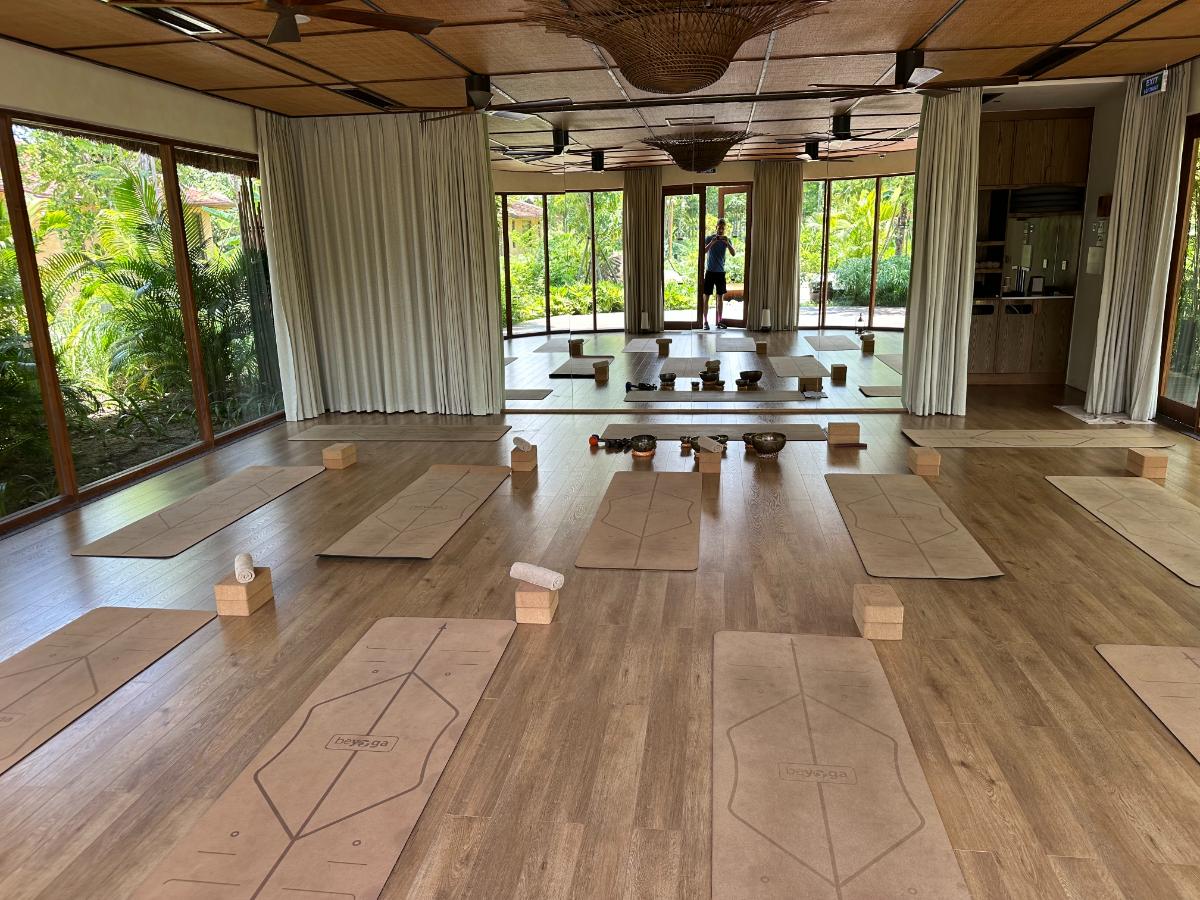 Yogastudio mit angeordneten Matten und raumhohem Glas zum Garten, Namia River Retreat, Hoi An, Vietnam